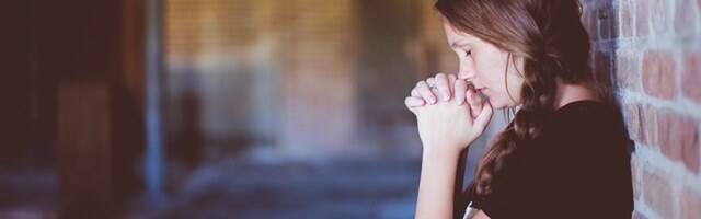 Chica joven rezando.