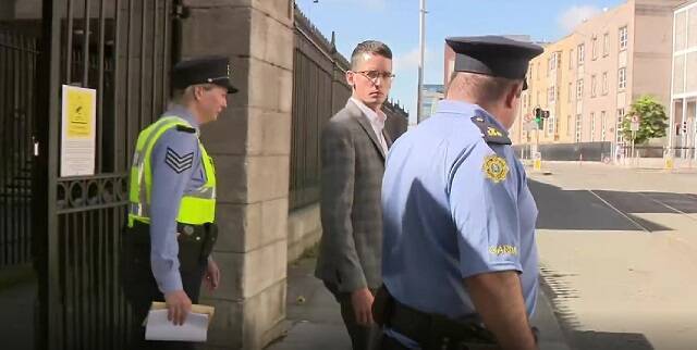 El profesor Enoch Burke con policías irlandeses deteniéndole