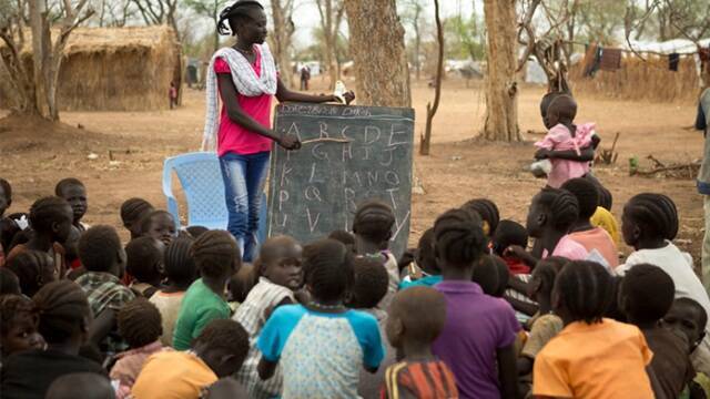 Una mujer enseñando a niños en África. 