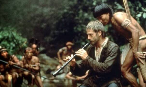 Con su oboe, el padre Gabriel atrae a los guaraníes y funda una misión en La Misión, película de 1986