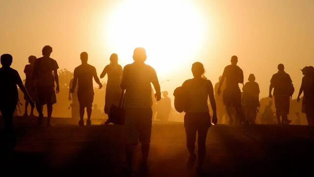 Gente caminando hacia el sol.