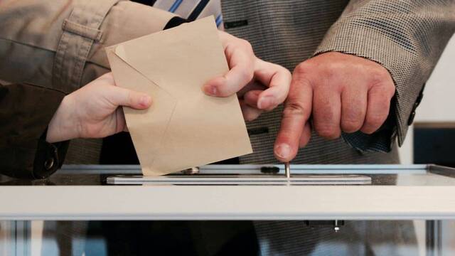 Persona votando en una urna.