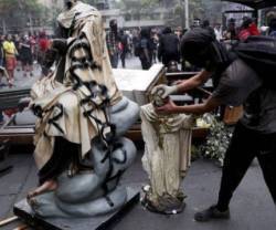 Un manifestante atacando figuras sagradas en Nicaragua.