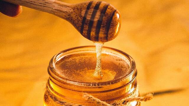 Cuchara y tarro de miel.