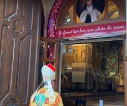 El obispo de Lisieux en la puerta del Jubileo, con la promesa de Teresita de enviar una lluvia de rosas, símbolo de favores
