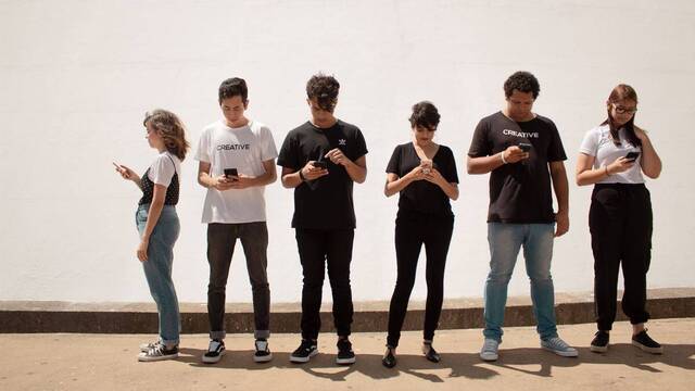 Adolescentes mirando el móvil.