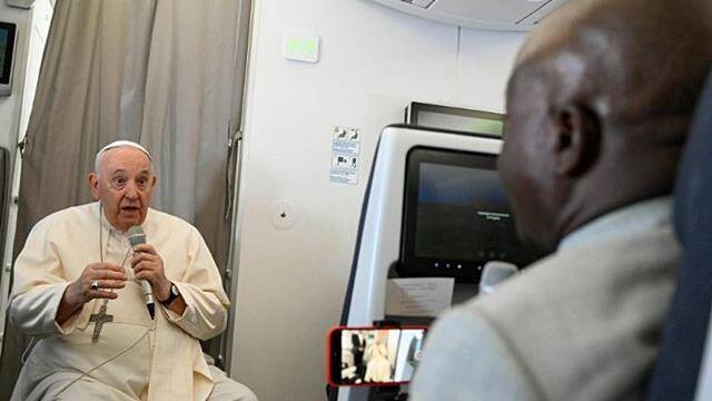 Francisco habla con un periodista en el avión de regreso de Sudán del Sur.