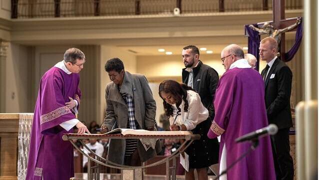 Unos catecúmenos de la diócesis de Kansas City - Saint Joseph firman en el Libro de la Vida