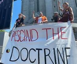En la misa del Papa Francisco en Quebec 4 activistas desplegaron la pancarta Rescindir la doctrina... llamada del descubrimiento