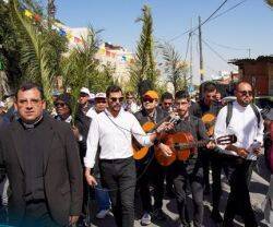 Curas con guitarras y peregrinos con palmas en Domingo de Ramos en Jerusalén 2023.