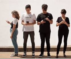 Jóvenes y adolescentes miran su móvil o iPhone