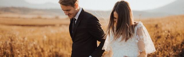 Recién casados pasean por el campo tomados de la mano - foto de Sandro Crepulja en Pexels