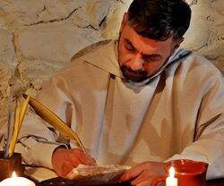 Un monje antiguo escribiendo con pluma en el documental 'La llama de Europa: San Bernardo de Claraval' de HM Televisión.