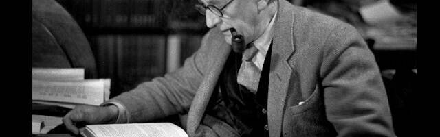 JRR Tolkien con pipa leyendo un libro en una foto en blanco y negro