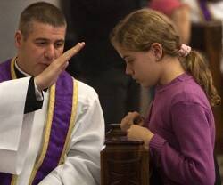 Un sacerdote imparte la absolución a una muchachita en confesión