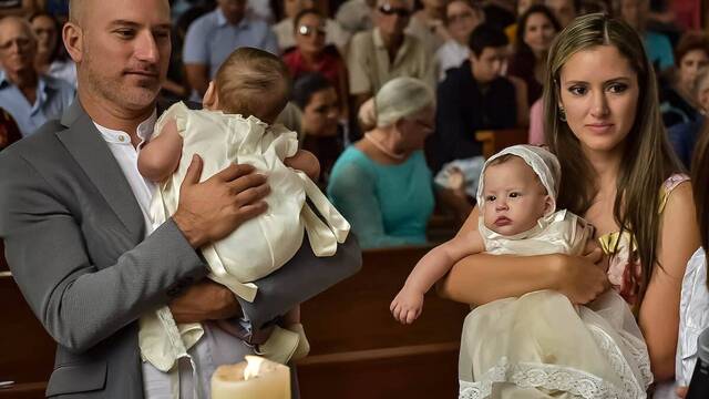 Un matrimonio con sus dos bebés en la iglesia.