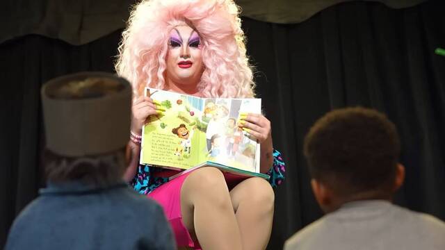 Drag Queen leyendo cuentos a niños en un colegio.