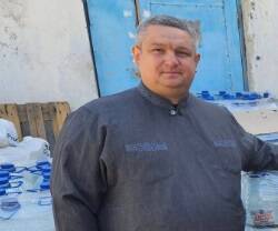 El padre Oleksander y una parroquiana de la parroquia de Berislav en Ucrania, en un reparto de agua