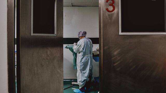 Una enfermera junto a una camilla de quirófano.