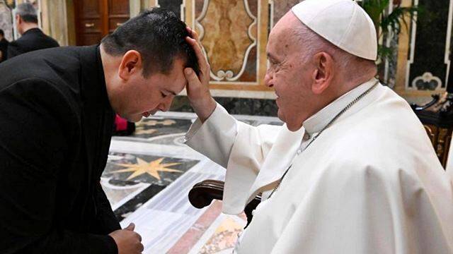Francisco bendice a un sacerdote.