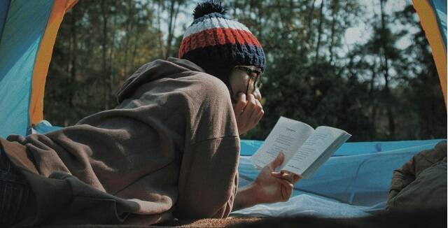 Una joven o adolescente absorta en la lectura en pleno invierno - foto de Le Tan en Unsplash