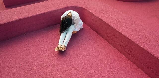 Una mujer sola y triste en una foto de Verne Ho en Unsplash