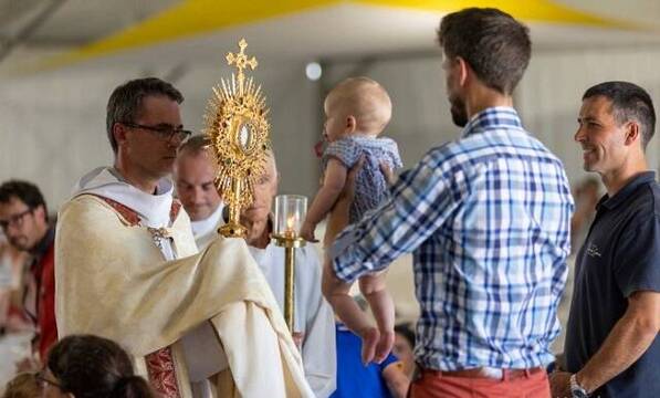 El padre Kern bendice una familia con el Santísimo en Paray-le-Monial