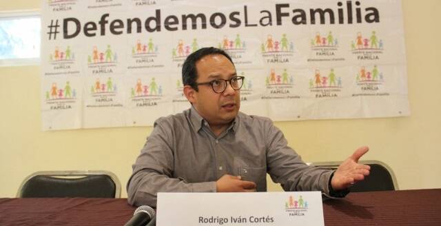 Rodrigo Iván Cortés habla con logos del Frente Nacional de la Familia