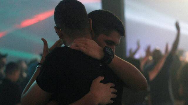 Dos jóvenes se abrazan en una fiesta.