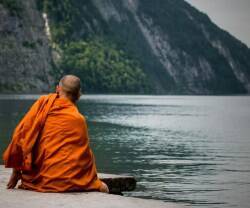 Un monje budista mirando un lago.  