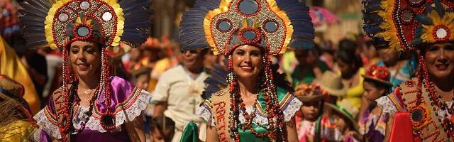 Tres chicas jóvenes con colores brillantes en un festival hispanoamericano