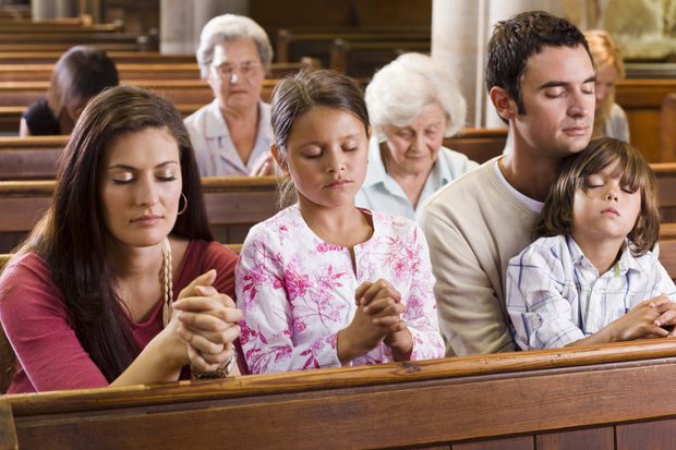 Una familia reza unida en la iglesia